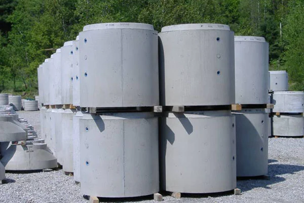 Precast concrete manhole rings stacked in a yard